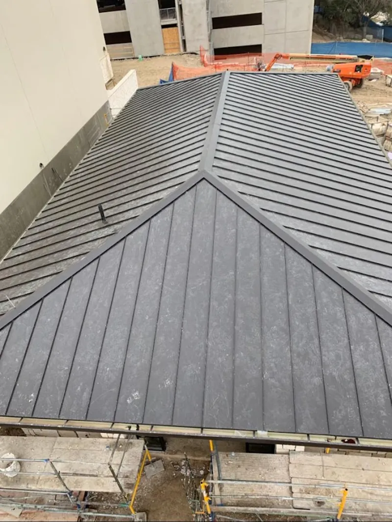 Commercial metal roof construction with crane equipment in Petaluma